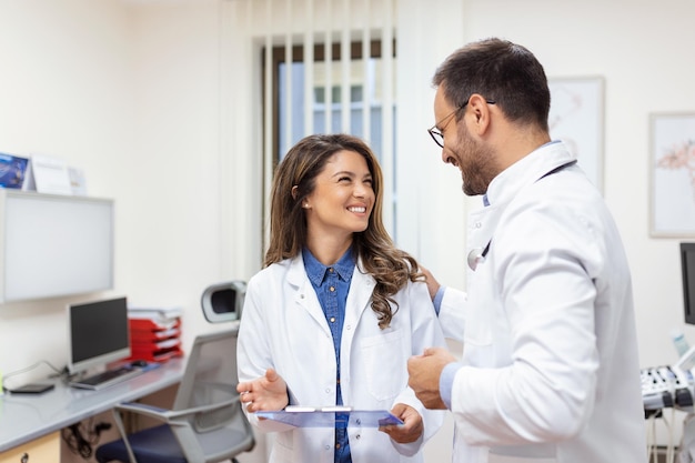 Médecins discutant d'un rapport médical à l'hôpital Médecin féminin et masculin vérifiant le rapport clinique du patient en ligne Personnel de santé discutant dans un bureau de clinique privée