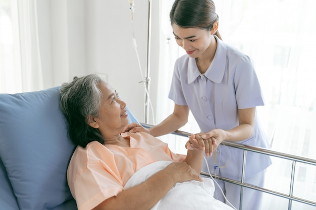 Les médecins se tiennent la main pour encourager les femmes âgées âgées dans le concept de soins médicaux et de soins de santé pour femmes âgées