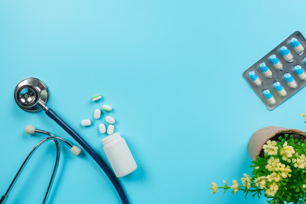 de médicaments, fournitures médicales placées avec des outils de médecin sur un bleu.