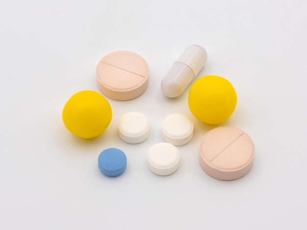 Médicaments en pilules colorées, gélules et gouttes. isolé sur fond blanc.