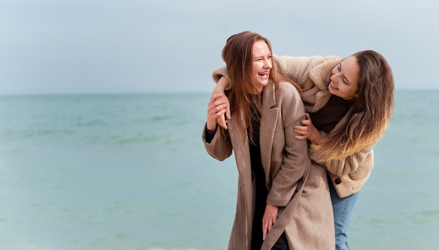 Photo gratuite meidum a abattu des femmes heureuses au bord de la mer