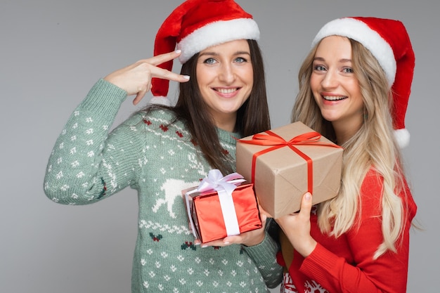 Meilleurs amis en chapeaux de Père Noël avec des cadeaux de Noël.