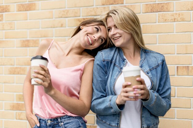 Meilleurs amis posant avec leurs tasses de café