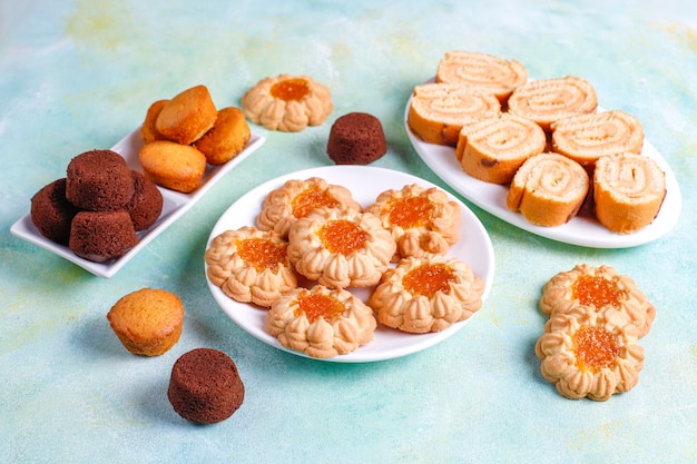 Mélange de biscuits sucrés, cake roll, mini cupcakes.