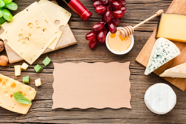 Mélange de fromage plat poser des raisins et du miel avec du carton blanc