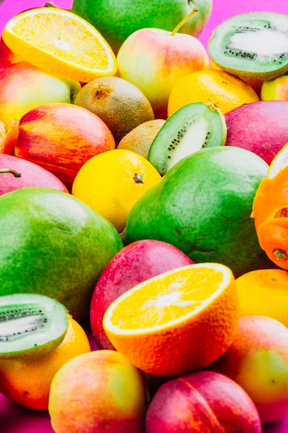 Photo gratuite mélange de fruits entiers et tranchés colorés