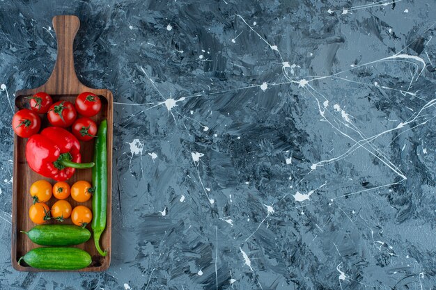 Mélange de légumes sur une planche, sur le fond de marbre.