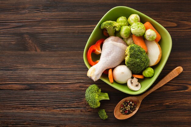 Mélange de légumes plat et pilon de poulet dans un bol avec espace de copie