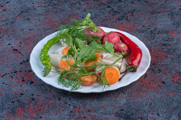 Mélange de légumes savoureux sur un plateau blanc sur fond de couleur sombre. photo de haute qualité