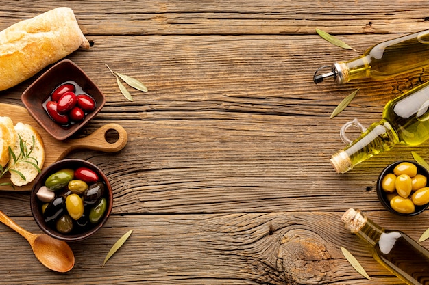 Mélange d'olives dans des bols de bouteilles d'huile d'olive et de pain avec espace de copie