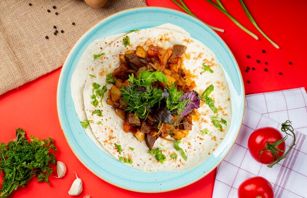 Mélange de viande frite et de légumes sur lavash