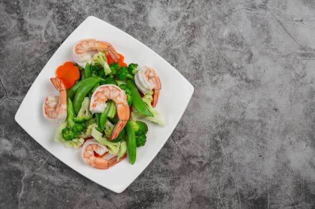 Mélanger les légumes frits avec les crevettes.