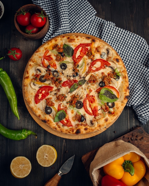 mélanger la pizza avec des tranches de tomates, champignons et olives
