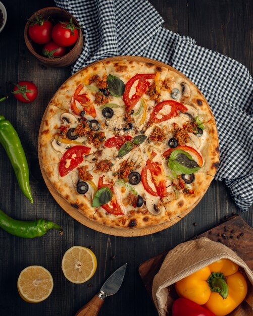 mélanger la pizza avec des tranches de tomates, champignons et olives