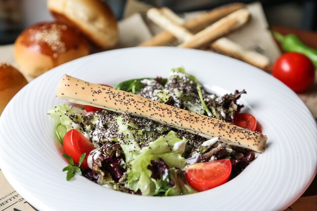 Mélanger salade verte laitue tomate sauce sésame poivron vue latérale