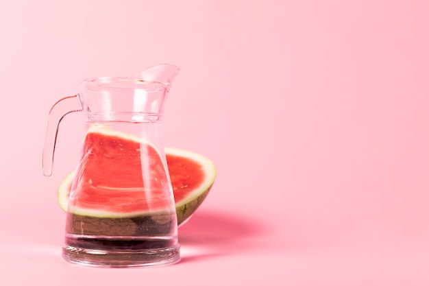 Melon d'eau demi-tranché avec un pichet d'eau