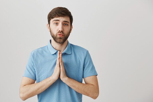 Mendicité jeune homme barbu stupide et sombre posant