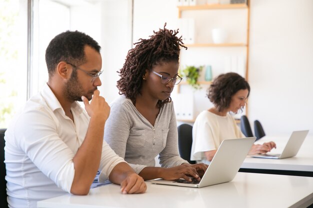 Un mentor regarde un stagiaire travailler sur ordinateur