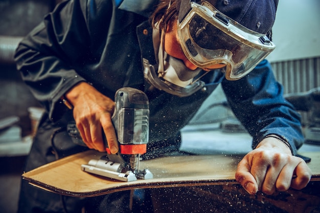 Menuisier utilisant une scie circulaire pour couper des planches en bois.