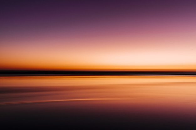 Mer pendant un coucher de soleil coloré avec une longue exposition