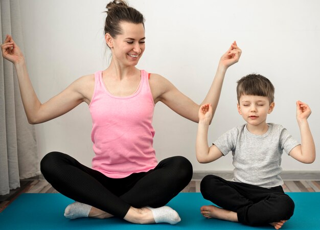 Mère active pratiquant le yoga avec son fils