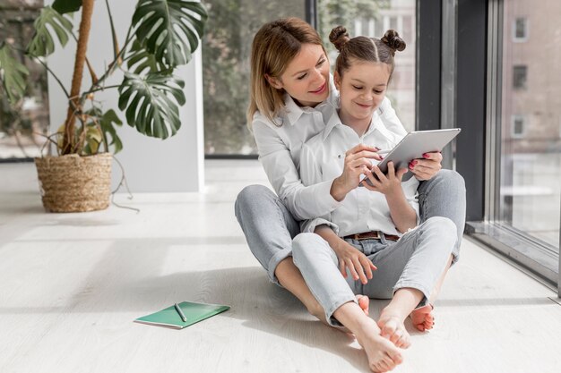 Mère aidant sa fille à étudier à l'intérieur