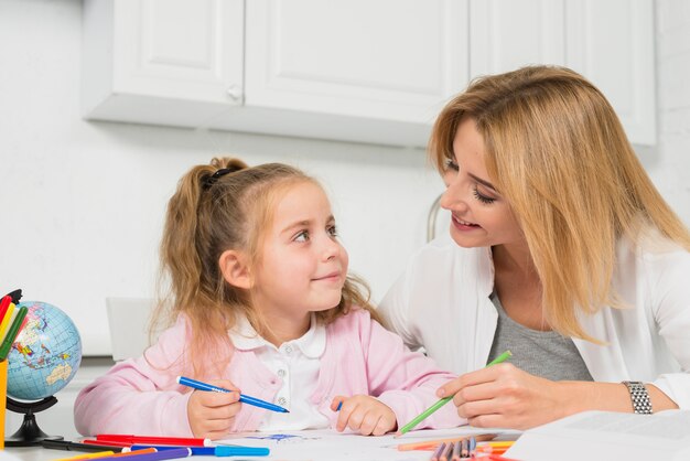 Mère aidant sa fille à faire ses devoirs