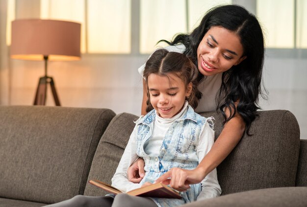 Mère aidant sa fille à lire