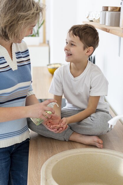 La mère aide l'enfant à se laver les mains