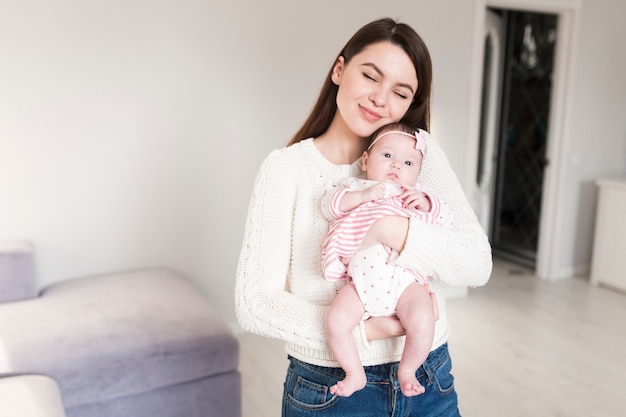 Mère aimante avec bébé sur les mains