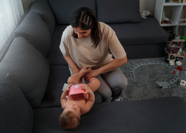 Mère à angle élevé changeant bébé