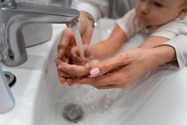 Photo gratuite mère à angle élevé lavant bébé