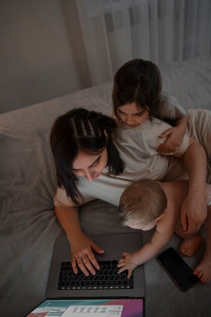 Mère à angle élevé avec ordinateur portable et enfants