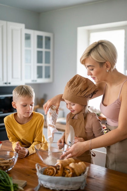 Photo gratuite mère apprenant à ses enfants à cuisiner à la maison