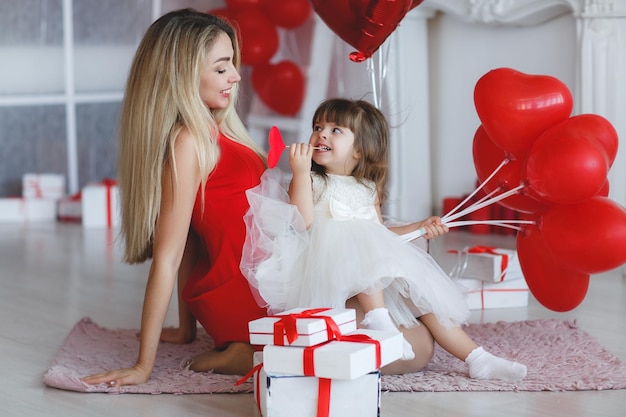 mère avec bébé mignon avec des ballons et des cadeaux