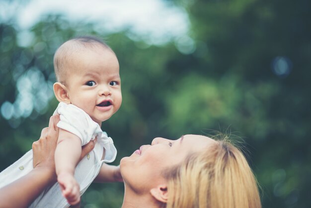 Photo gratuite mère avec bébé, rire et jouer dans le parc