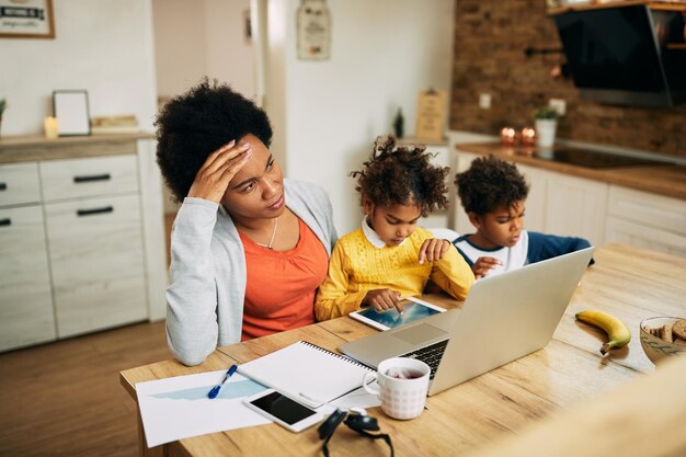 Une mère célibataire afro-américaine se sent stressée en travaillant à la maison