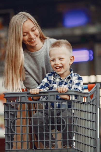 Mère Conduit Dans Un Chariot. Famille Dans Un Parking Près D'un Supermarché.