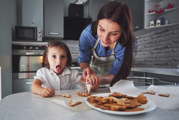 Mère cuit au four avec sa fille dans la cuisine.