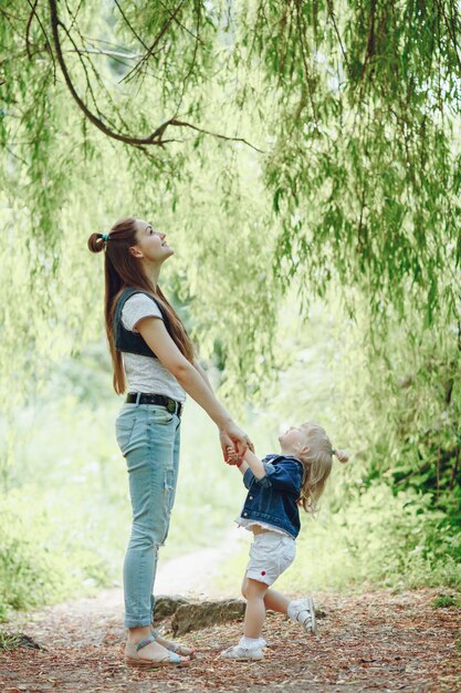 Mère debout tenant les mains de sa fille