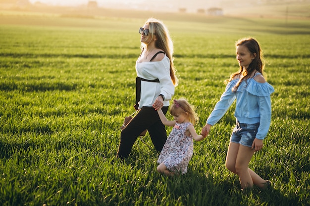 Mère avec deux filles au coucher du soleil