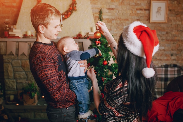 Mère distraire le bébé avec un ornement de Noël tandis que le père tient dans ses bras
