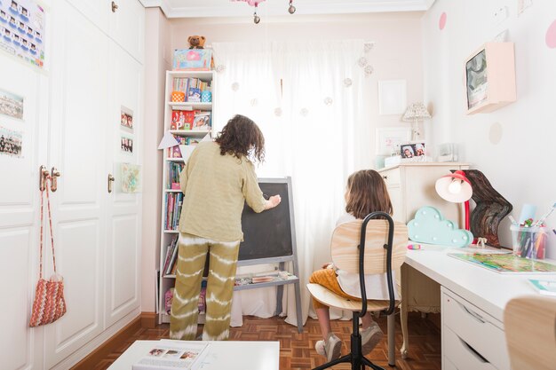 Mère écrit sur le tableau pour la fille