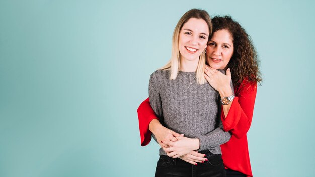 Mère embrassant la fille souriante