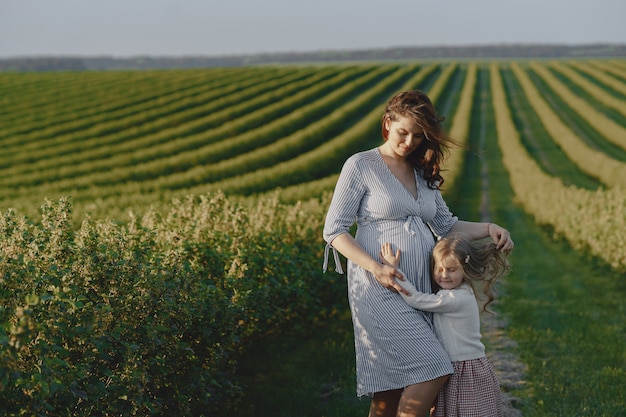 Mère enceinte avec sa fille dans un champ