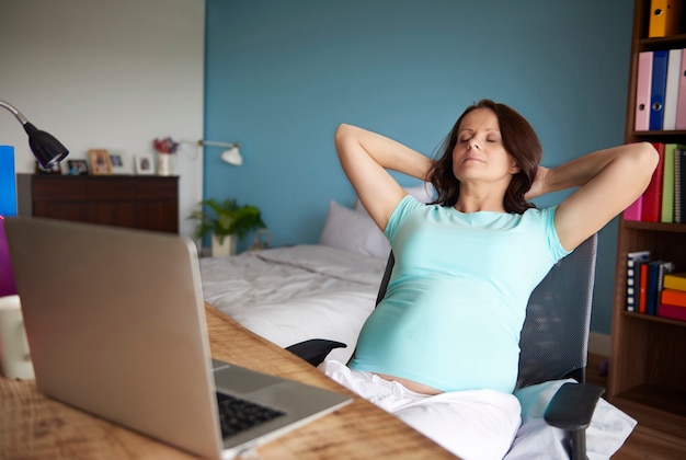 Mère enceinte se détendre dans la chambre