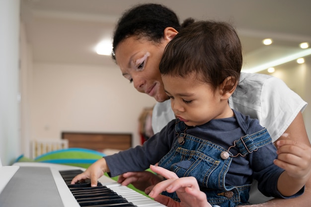 Photo gratuite mère et enfant jouant du piano