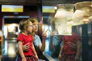 Photo gratuite mère et enfant à la recherche de vieilles amphores dans le musée