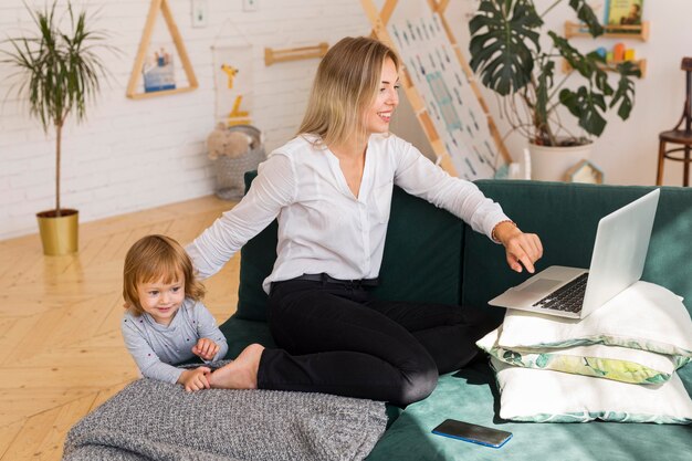 Mère avec enfant travaillant à la maison