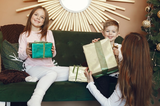 Mère avec des enfants mignons près de l'arbre de Noël